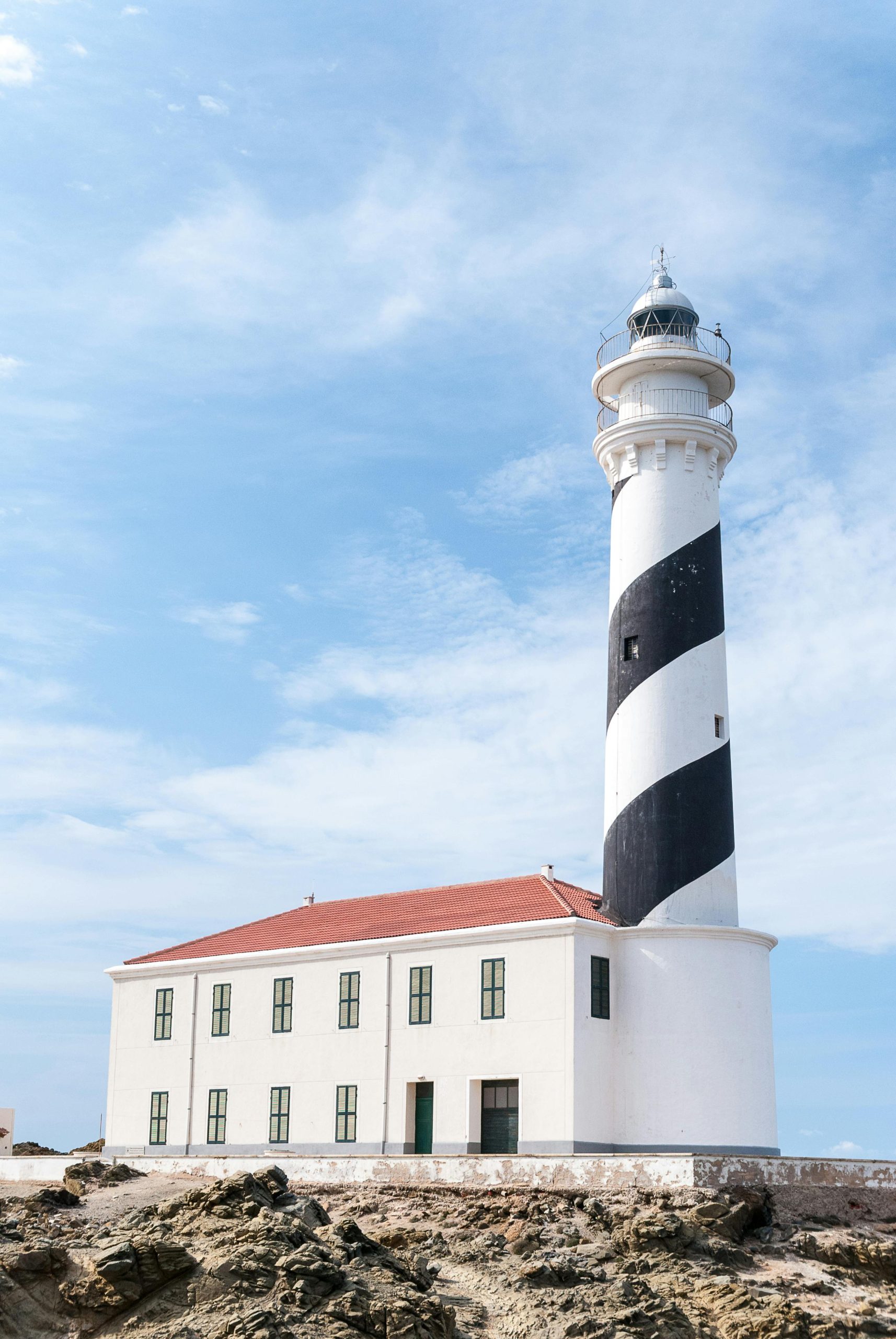 Drive 4 lighthouse loop Menorca - Favaritx lighthouse on the dark slate rock of the north-east peninsula.