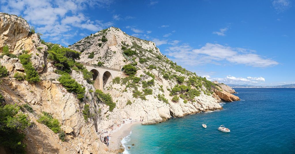 A limestone calanque fjord with turquoise water between sheer white cliff walls near Cassis on the Calanques coast between Marseille and La Ciotat in clear Mediterranean light.
