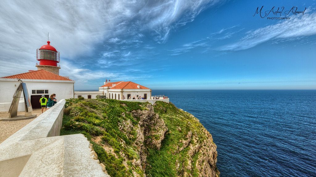 Cape St Vincent lighthouse Algarve west coast Portugal at sunset with Atlantic cliffs below.