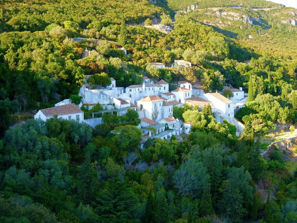 Car hire in Lisbon day trip Serra da Arrabida Natural Park limestone cliffs turquoise water.