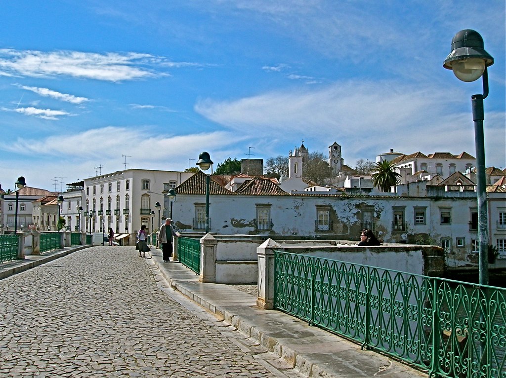 Route à travers l'est de l'Algarve : Tavira, le pont romain sur le Rio Gilao, au Portugal – une ville aux murs blanchis à la chaux et aux toits de terre cuite, avec la lagune en arrière-plan.