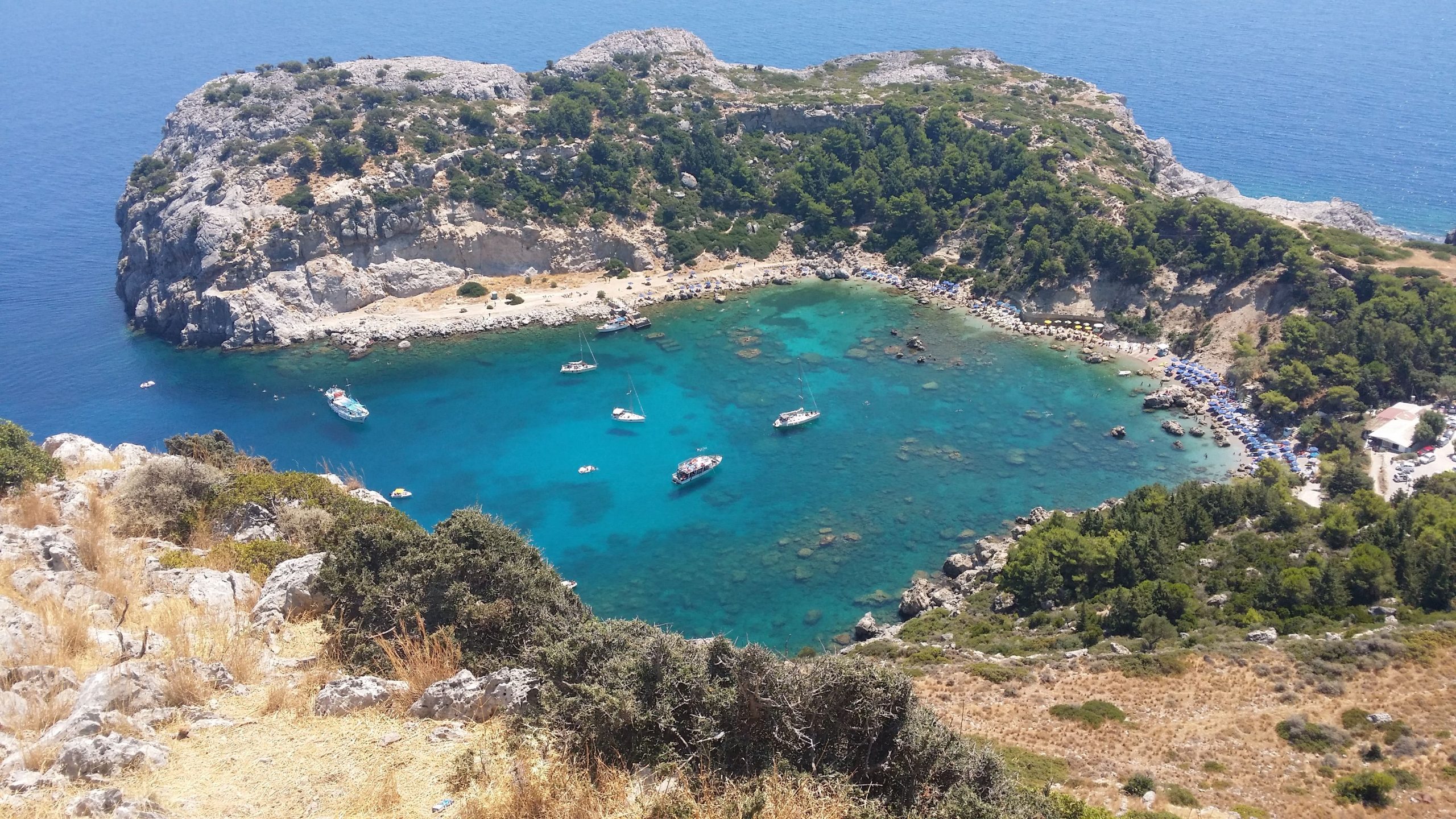 The golden sand and blue lagoon water of Tsambika Beach, Rhodes